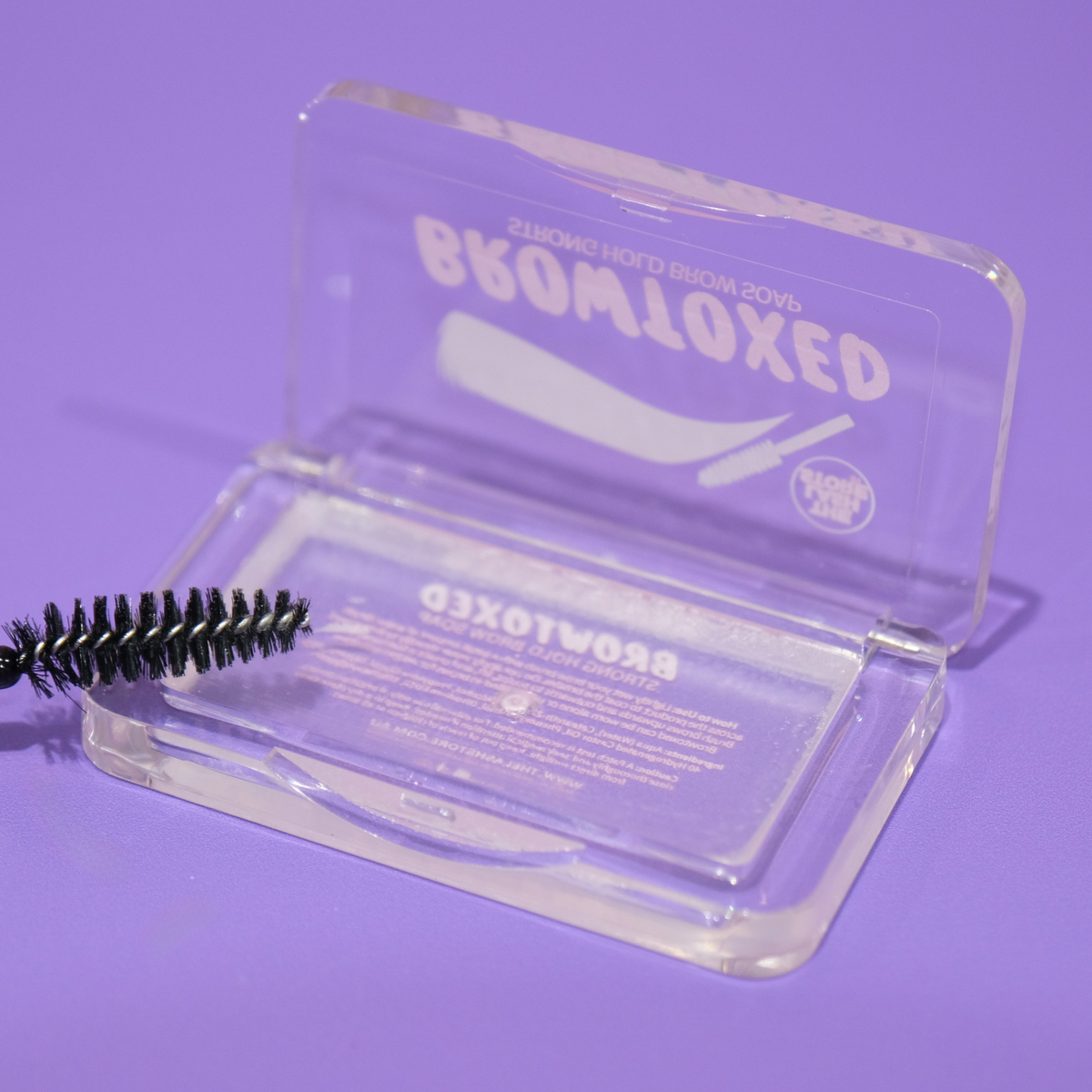 Clear packaging with a brush and 'Browloxed' branding on a purple background