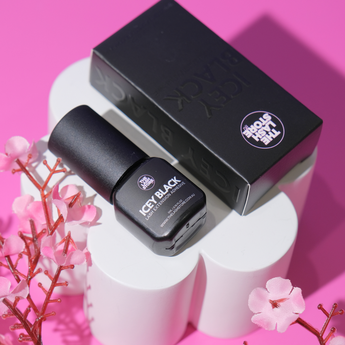 Black nail polish bottle and box with 'ICEY BLACK' on a pink background